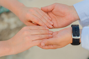 Man and woman, newlyweds holding hands with blurred background.