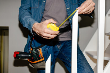 Man Using Yellow Tape Measure During Renovation