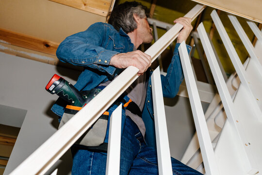 Man Installing White Stair Railing