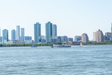 Skyline view of a city across a body of water with boats on a bright sunny day showing the architectural beauty and busy waters.