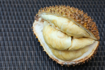 Fresh ripe durian on wicker table, above view. Space for text
