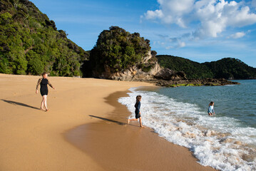 Family enjoying morning swim, Abel Tasman National Park, New Zealand.