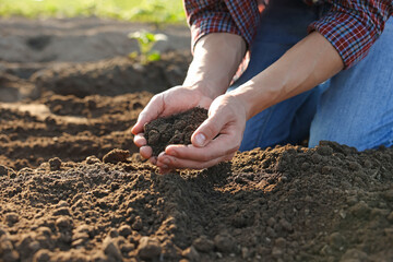 Man holding pile of soil in field, closeup
