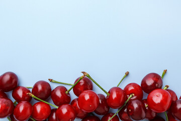 Fresh ripe cherries on light background, flat lay. Space for text