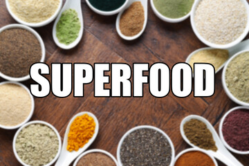 Superfood. Different powders in bowls and spoons on wooden table, flat lay