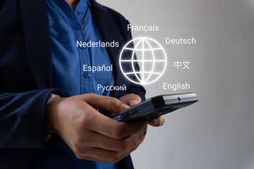 Businessman hands holding smartphone with globe icon and various languages ​​around, language...