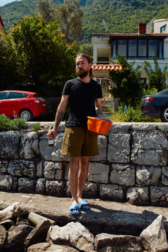 Man carries a bowl on the seashore