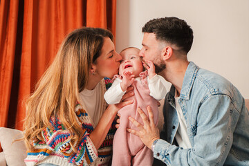 This delightful image captures the heartwarming moments of loving parents showering kisses on their...