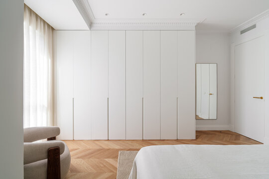 Minimalist wardrobe with natural light and full-height doors