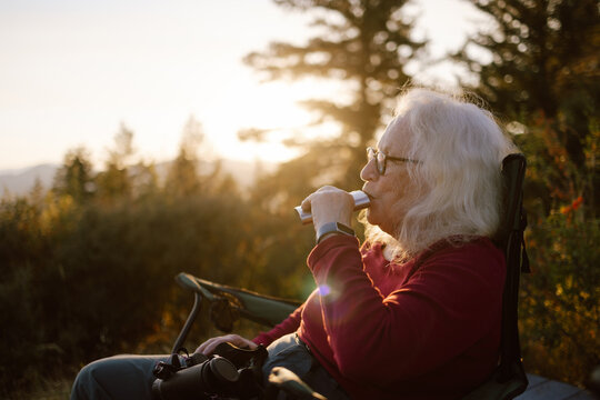 Woman sipping flask during sunset