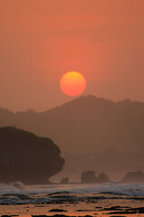 orange sunset photo with the sillhouette of hill