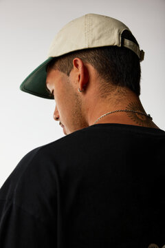 Young man wearing a cap and black shirt in a modern setting
