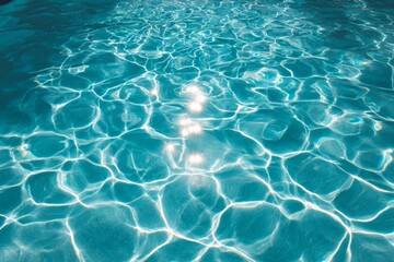 Fototapeta premium Sunlit ripples on clear blue water surface with reflective patterns