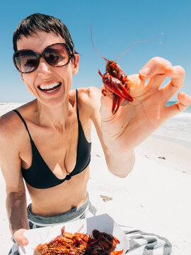 Happy Woman Eating Local Food at Beach