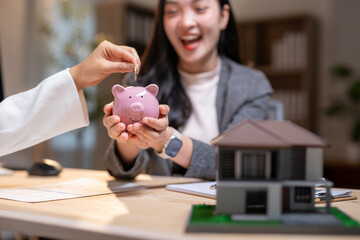 A woman is holding a piggy bank and smiling