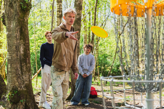 Friends Playing Disc Golf, Aiming a Frisbee at the Basket