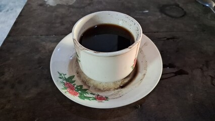 Antique Indonesian Coffee Cup Filled with Black Coffee on Vintage Saucer in Traditional Village Warung Setting