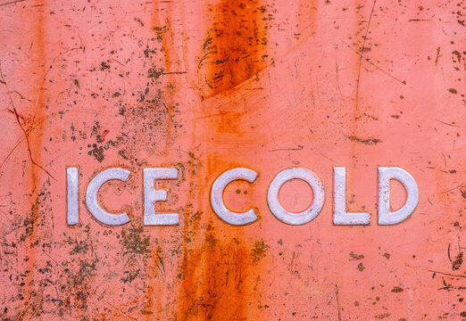 Ice Cold sign on very old, rusty refrigerator case