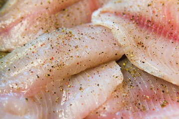The texture of raw fish pieces sprinkled with pepper. Closeup