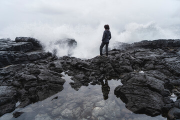 Watching crashing waves on volcanic coast of Pico Island