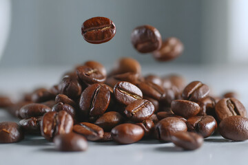Close-up of roasted coffee beans falling and piling on a smooth surface, macro shot highlighting texture and aroma
