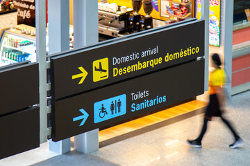 Airport sign indicating domestic arrivals area and toilets
