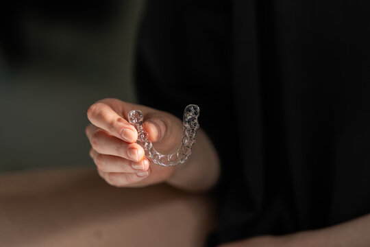 Hand Holding Clear Dental Aligner