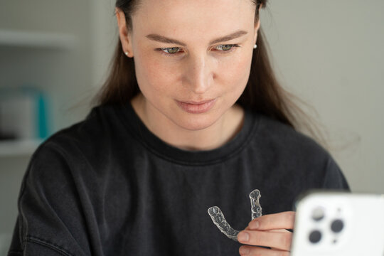 Woman Holding Dental Aligner During Video Call
