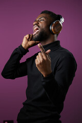 Energetic young man singing passionately while wearing headphones, showcasing joy and love for...