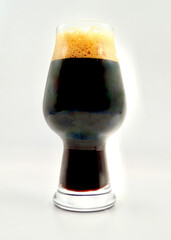 A closeup of a glass of porter style beer isolated against a white background.
