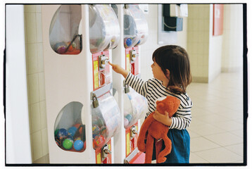 Child Using Toy Vending Machine with Plush Toy