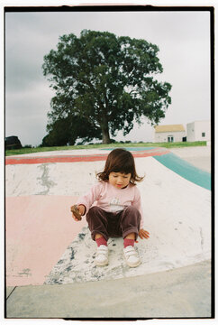 Child Sitting on Painted Surface in Outdoor Par