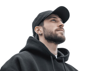 A young man in a black hoodie gazes thoughtfully upwards against a plain gray background. conveying a sense of contemplation and introspection. ideal for lifestyle or fashion themes