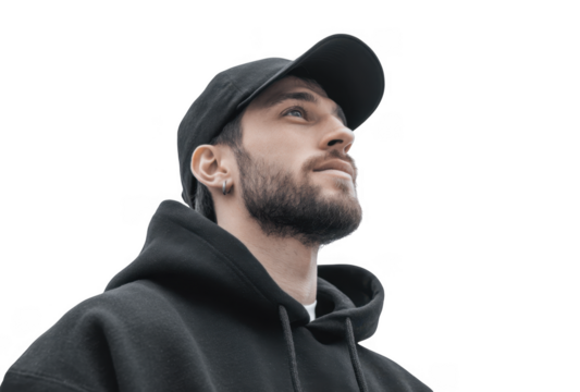 A young man in a black hoodie gazes thoughtfully upwards against a plain gray background. conveying a sense of contemplation and introspection. ideal for lifestyle or fashion themes