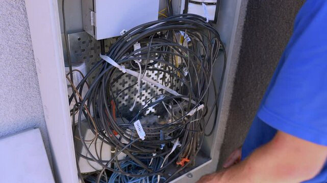 The Cable Technician secures the cables inside the Dmarc
