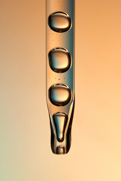 Glass pipette with anti-age moisturizing face serum on orange backdrop