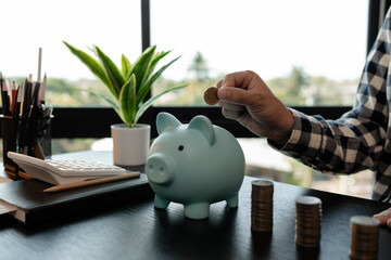 he is saving money for his future plans, putting some if his income in a piggy bank, he is saving...