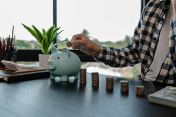 he is saving money for his future plans, putting some if his income in a piggy bank, he is saving...