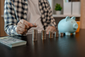 he is saving money for his future plans, putting some if his income in a piggy bank, he is saving...