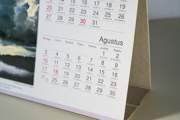 Close up of a white desk calendar showing specific date, captured from an angled macro perspective.