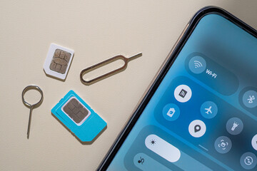 SIM tray and SIM card beside a smartphone