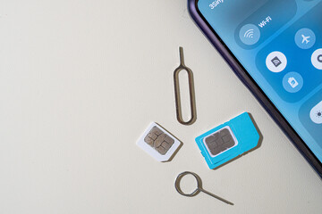 SIM tray and SIM card beside a smartphone
