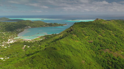 Tropical vegetation covers the mountain slopes of Bora Bora, a volcanic island in French Polynesia,...