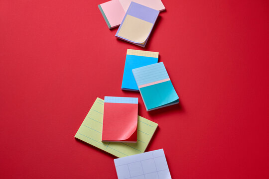 A collection of colorful sticky notes scattered on a red background
