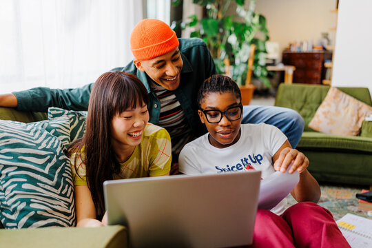 Roommates studying together using laptop at home