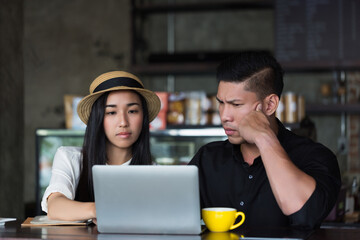 Frustrated couple facing difficulties while working remotely from cafe. Perfect for concepts like...
