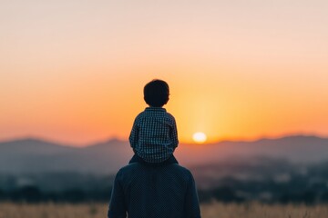 Father carrying his son on his shoulders, enjoying a stunning sunset over a picturesque landscape filled with hills and vibrant colors