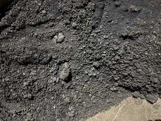 Dark, rough texture of fine coal under natural light, perfect for backgrounds
