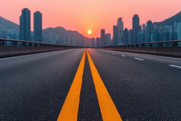 Fototapeta premium Modern highway leading to Hong Kong cityscape at sunset, featuring vibrant orange road markings and a tranquil atmosphere