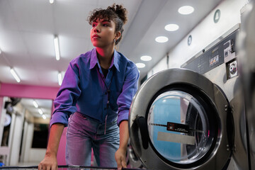Woman keeping an eye on work while doing laundry